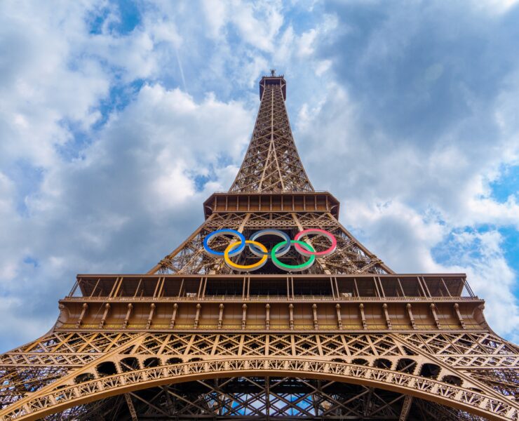 a tall metal tower with olympic rings on top