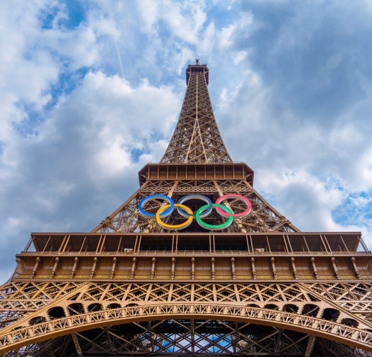 a tall metal tower with olympic rings on top