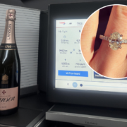 a champagne bottle and a ring on a finger