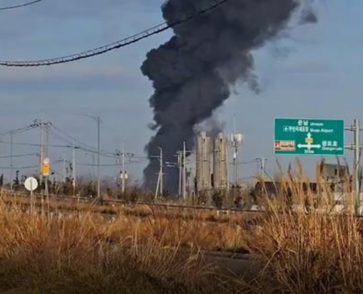 a black smoke billowing from a factory