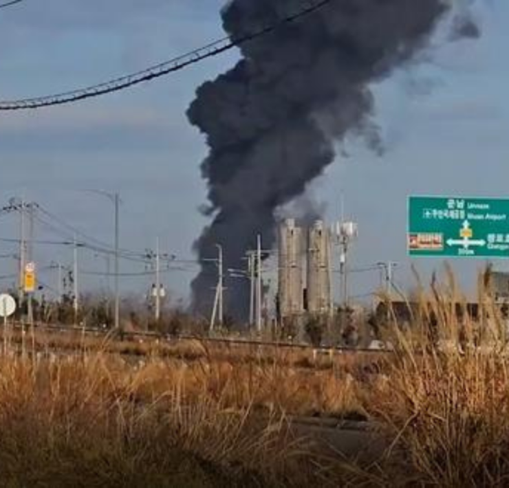 a black smoke billowing from a factory