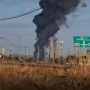 a black smoke billowing from a factory