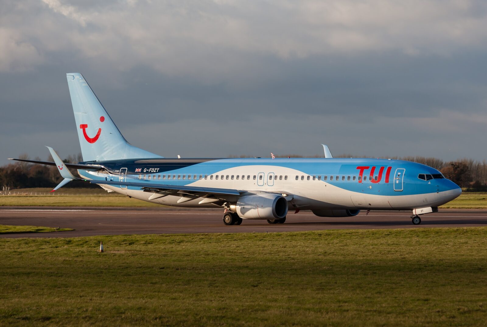 a blue and white airplane on a runway