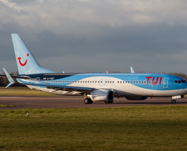 a blue and white airplane on a runway