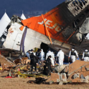 a group of people in white uniforms near a crashed plane