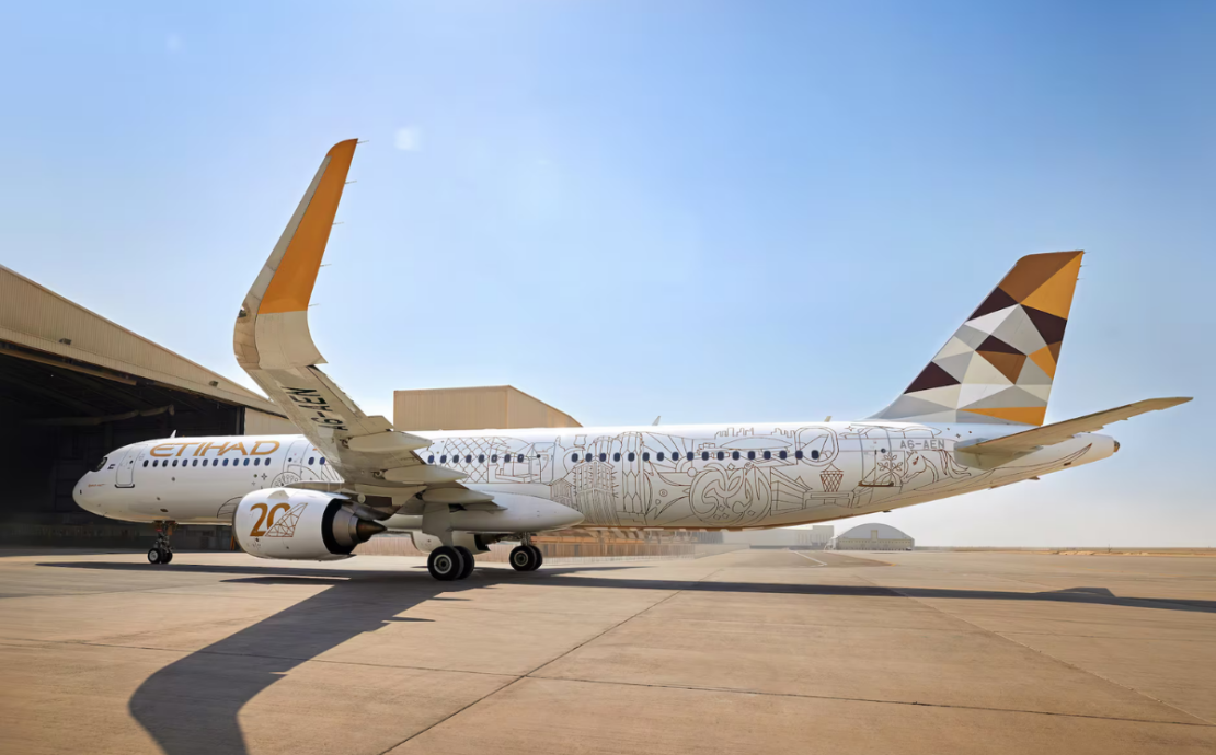 a large white airplane with a yellow and brown design on it