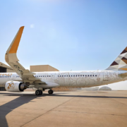 a large white airplane with a yellow and brown design on it