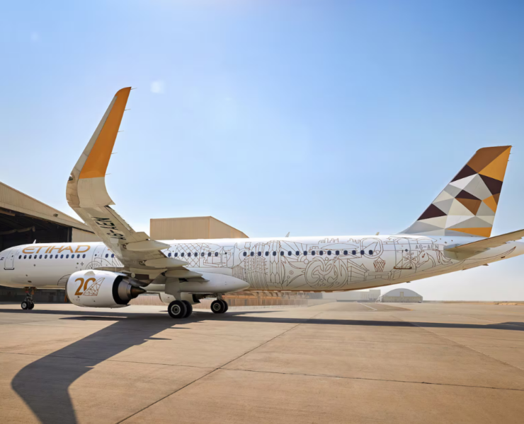 a large white airplane with a yellow and brown design on it