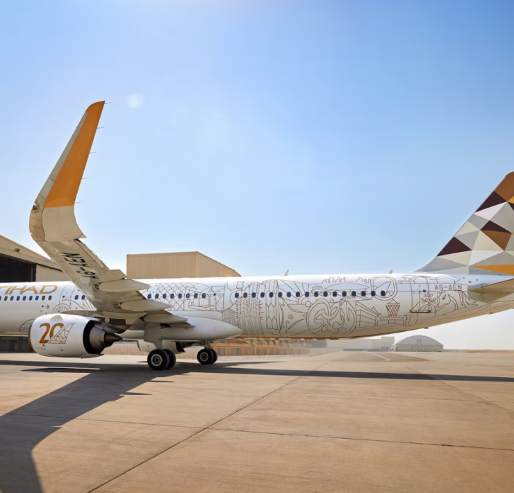 a large white airplane with a yellow and brown design on it