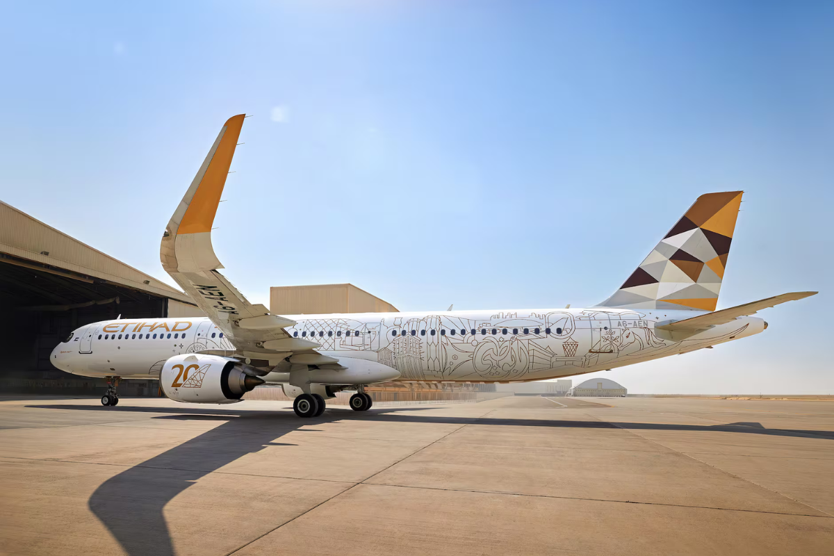 a large white airplane with a yellow and brown design on it