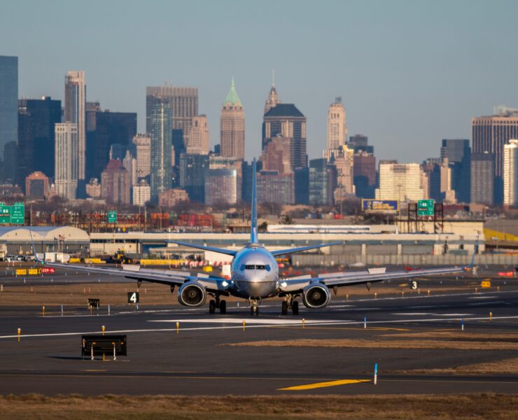 a plane on a runway with a city in the background