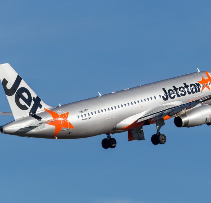 a silver airplane with orange and white text